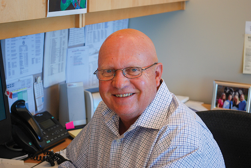 Dennis Lyon seated at an office desk