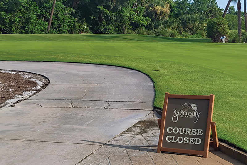 Golf course with sign saying the course is closed.