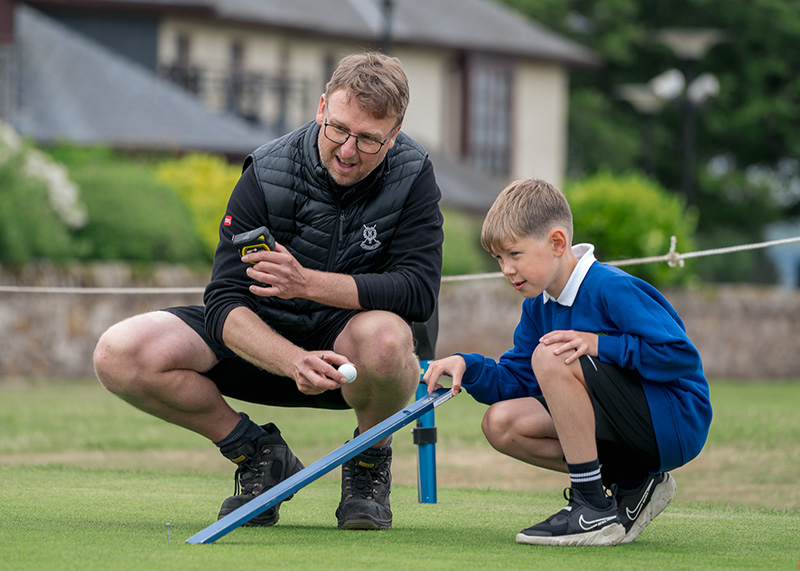 Student and St. Andrews Links crew member using a stimpmeter