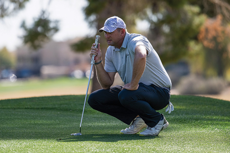 golfer examining his shot on a putting green