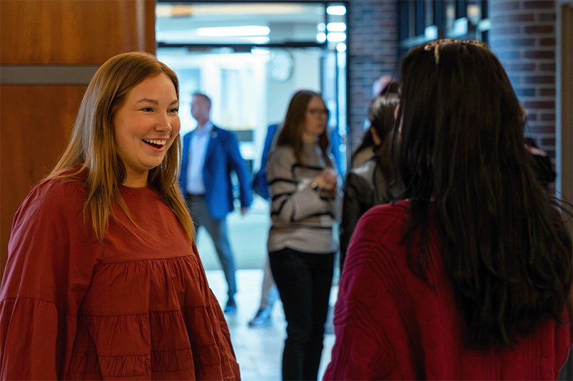 Two women speaking in an office building lobby