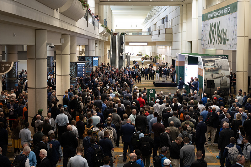 Large group of people in a conference center entering a trade show