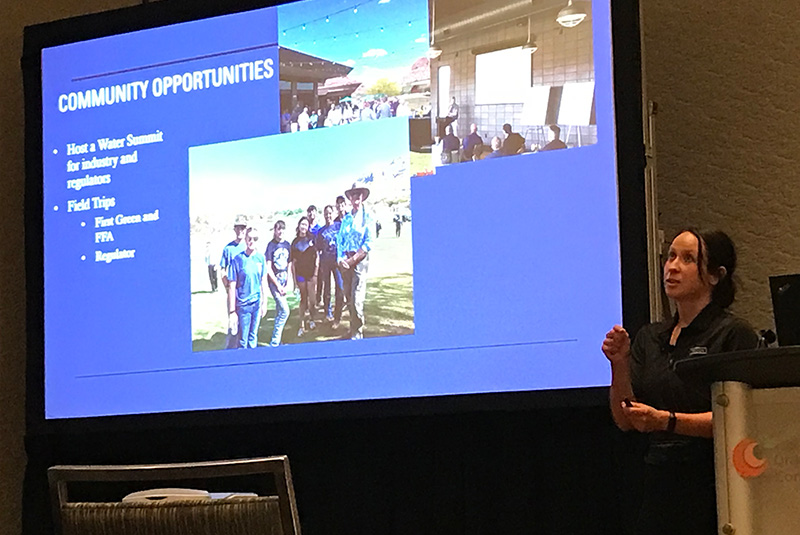 Woman speaking in front of a group of people in a conference room