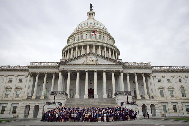 A large group of people stand on the steps of the U.S. Capitol Building