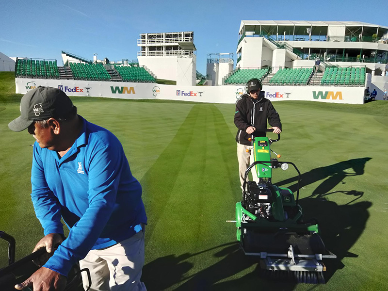 Crew members working the green at TPC Scottsdale