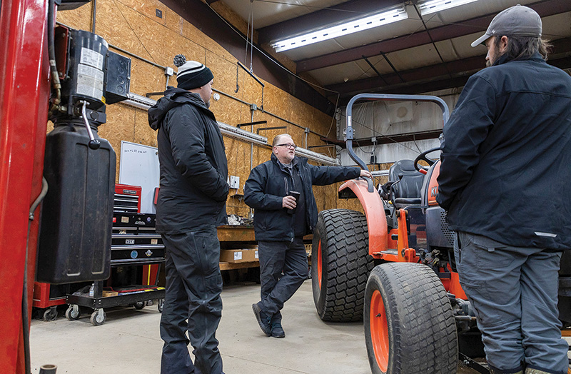 McCall talking with two men outside the maintenance shop