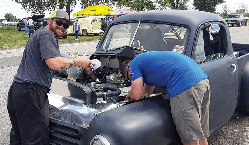 Two young men working on a classic car