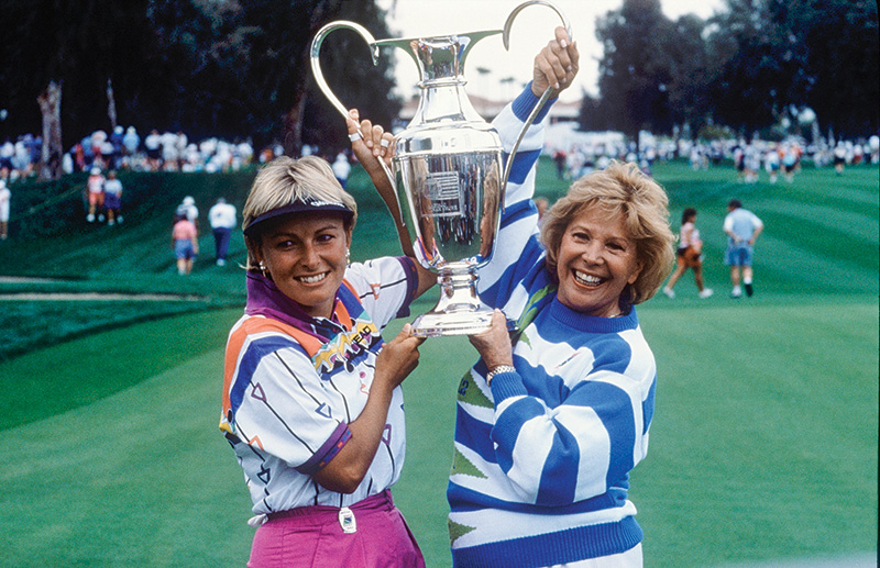 Dottie Pepper, left and Dinah Shore, right, lifting a trophy together