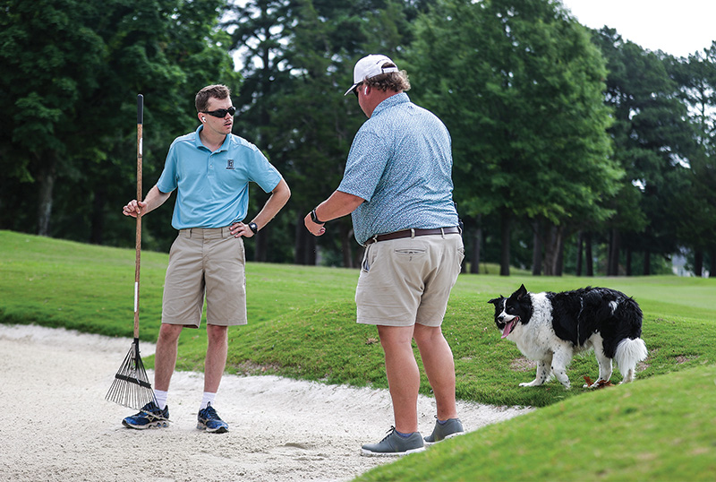 Bisanz and a black and white dog with a golfer