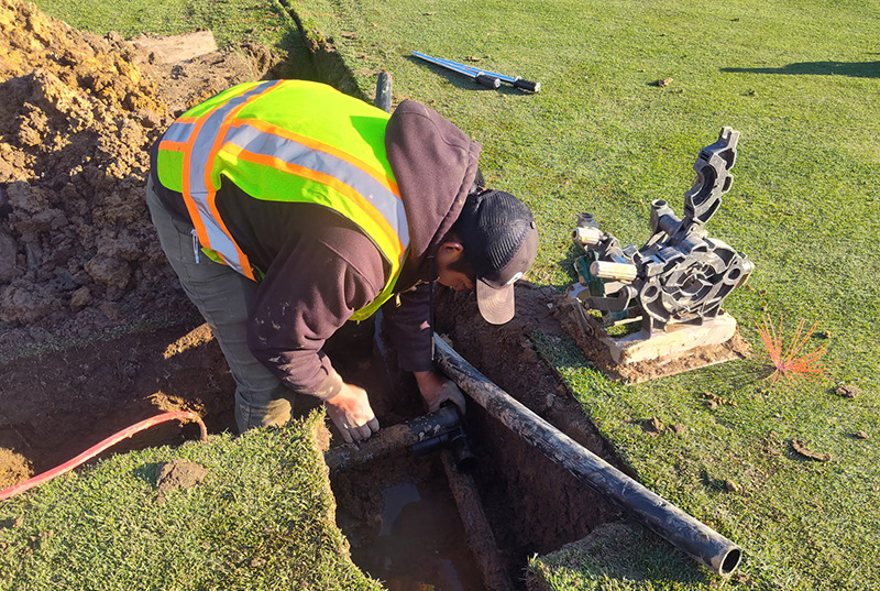 Man working on an in-ground irrigation system