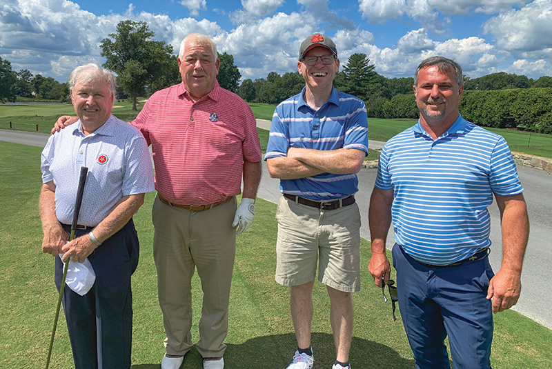 Group of men standing outdoors on a golf course