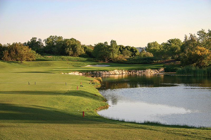 Golf course in daytime with water feature