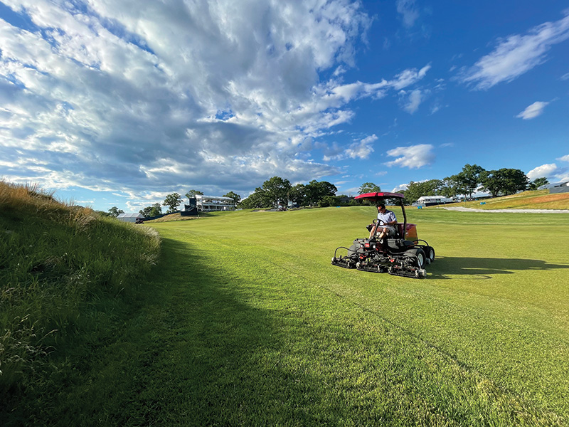 man mowing golf course