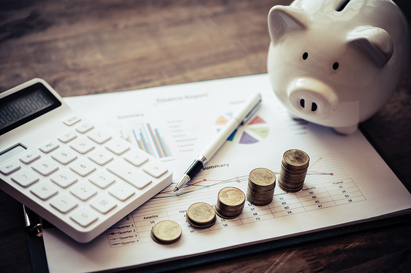 Photo illustration of money with a piggy bank and financial statement