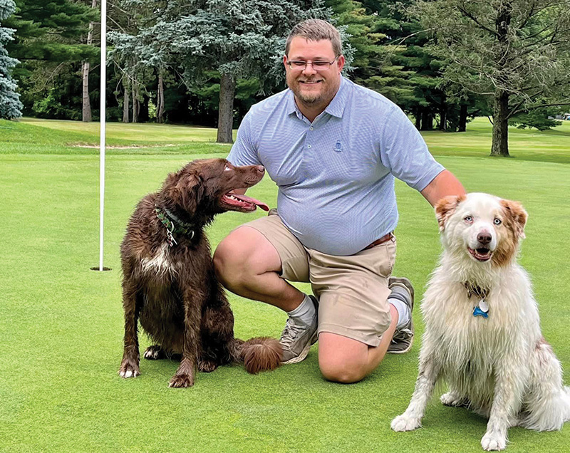Morrow on the golf course with two medium-size dogs
